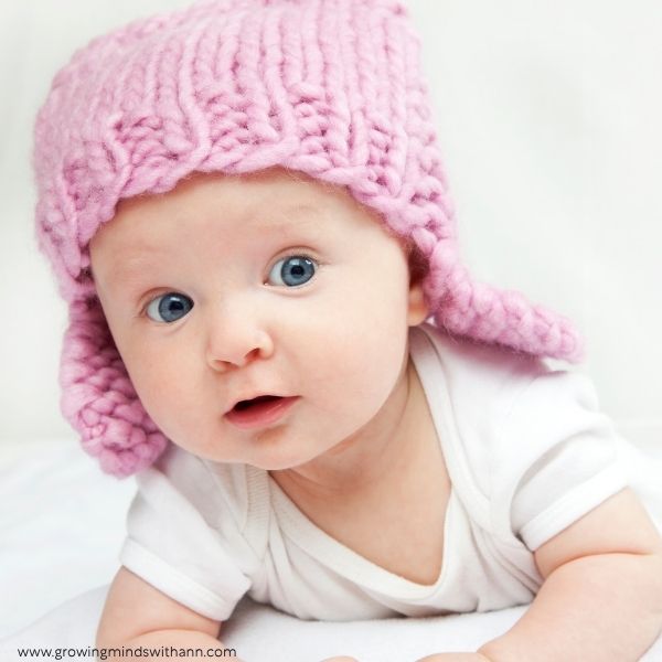 Baby-wearing-a-pink-hat-in-baby-photoshoot-ideas-at-home.