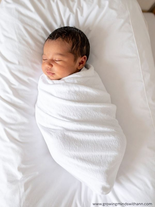Baby-wrapped-in-a-white-blanket-in-baby-photoshoot-ideas-at-home.