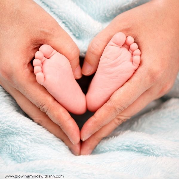 Hand-holding-baby's-tiny-feet-in-a-heart-shape.