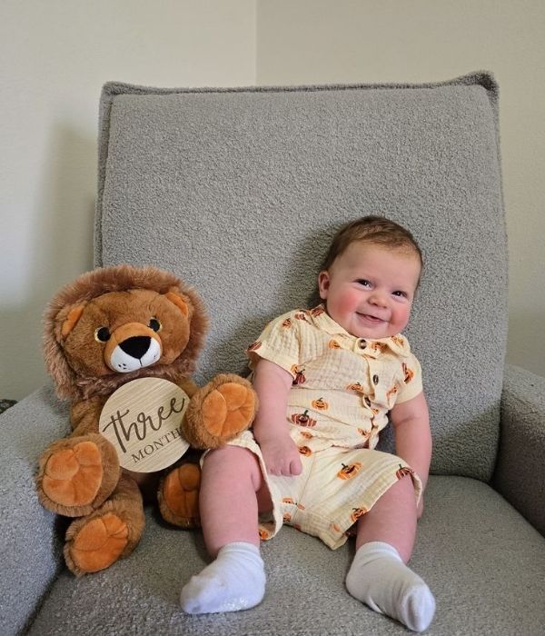 Baby-sitting-on-a-chair-with-teddy-bear-bearing-3-months-old-beside-in-baby-photoshoot-ideaas-at-home.