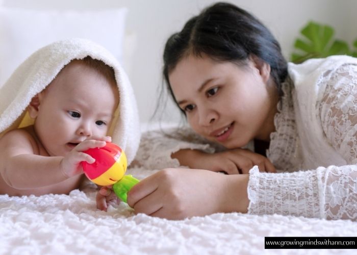 Mom-moving-toy-around-while-baby's-eye-follow-it-in-simple-activities-to-do-with-your-baby-at-home.