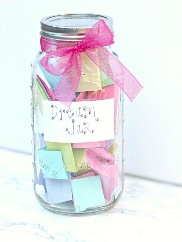 Clear-jar-with-piece-paper-written-goals.