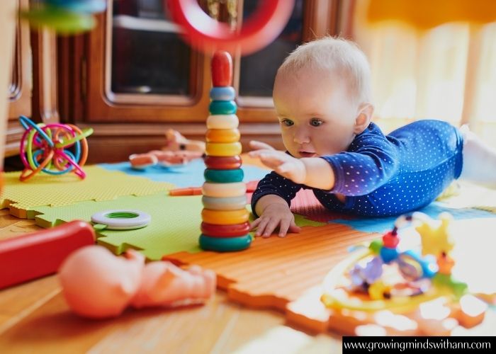 Baby-stretching-hand-to-reach-a-toy-in-simple-activities-you-can-do-with-your-baby-at-home.