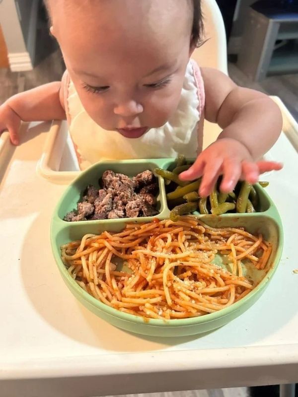 Baby-eating-pasta-and-shredded-chicken-in-healthy-finger-foo-ideas-for-babies-6-12-months.