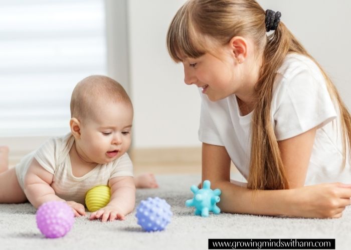 Baby-and-baby-lying-on-tummy-with-yellow-and-blue-toys-in-front-of-them-in-simple-activities-to-do-with-your-baby-at-home.