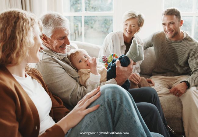 Grandpa-carrying-baby-while-mom-dad-and-grandma-discuss.