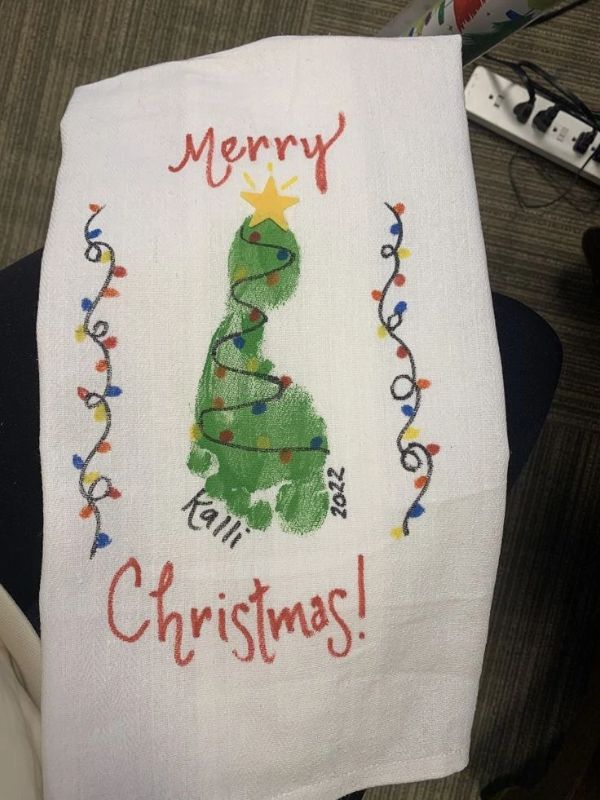 White-towel-designed-with-green-footprint-and-written-merry-christmas-with-red-color.