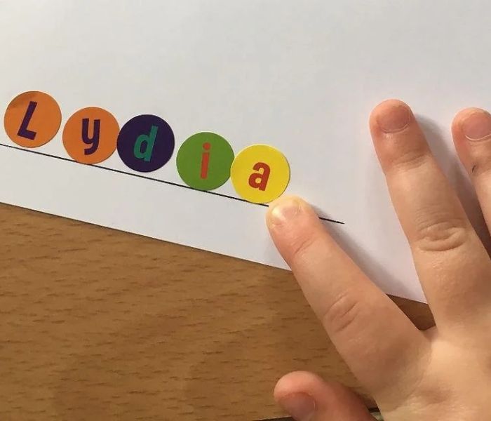 Kid-hand-playing-name-sticker-activity.