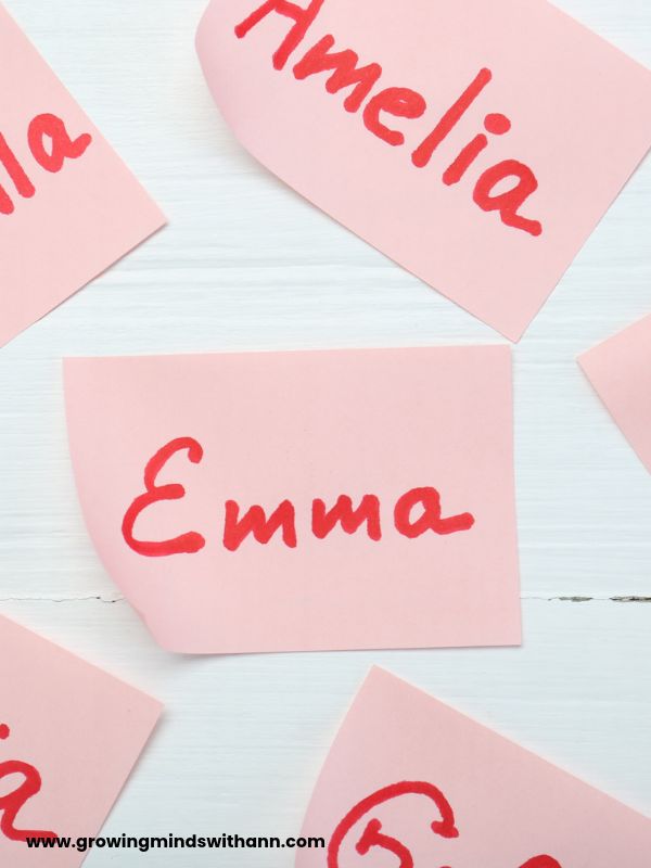 Different-names-written-on-a-pink-cardboard-with-red-marker-in-name-activities-for-preschoolers.