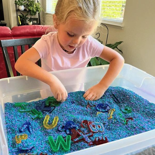 Child-playing-in-name-sensory-bin-in-name-activities-for-preschoolers.
